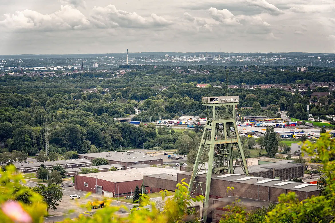 Panoramablick über das grünende Ruhrgebiet von der Halde Prosper Haniel aus gesehen, mit dem Förderturm der Zeche als Bildelement.